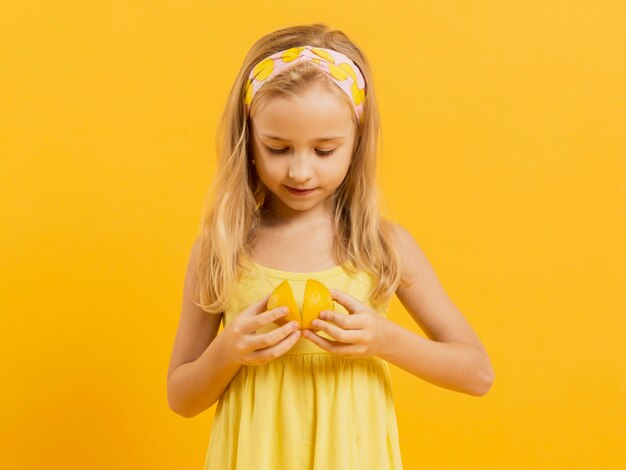 Vista frontal da garota segurando limão