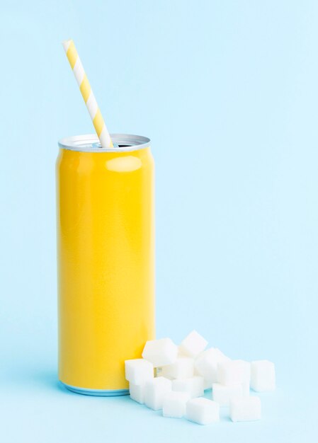 Vista frontal da lata de refrigerante com canudo e cubos de açúcar