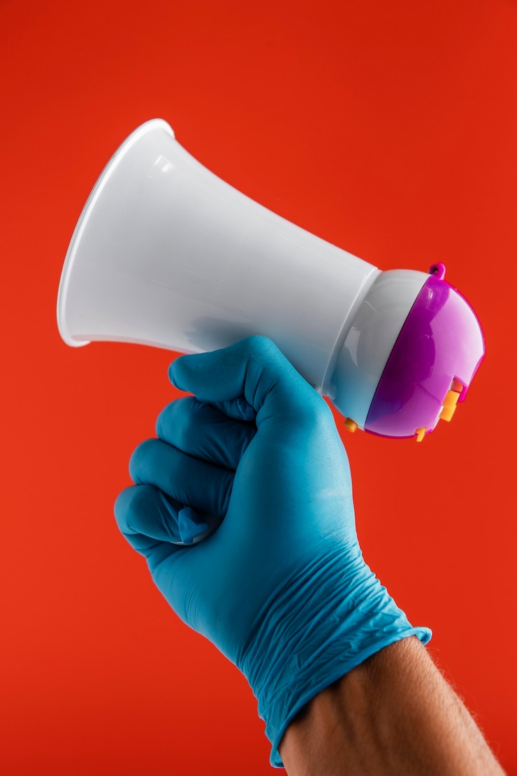 Foto grátis vista frontal da mão segurando o megafone enquanto usa uma luva