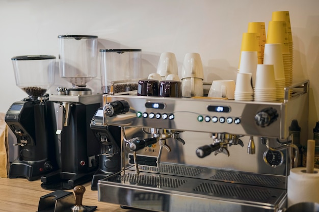 Vista frontal da máquina de café com um monte de xícaras