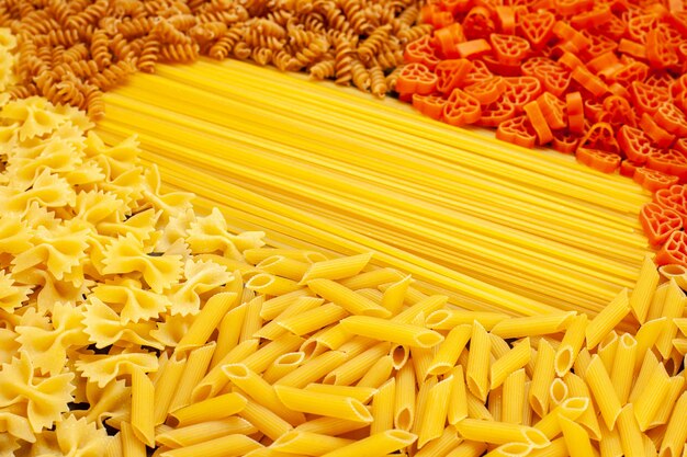 Vista frontal da massa italiana crua com formato diferente em massa cinza-claro culinária refeição foto cor comida