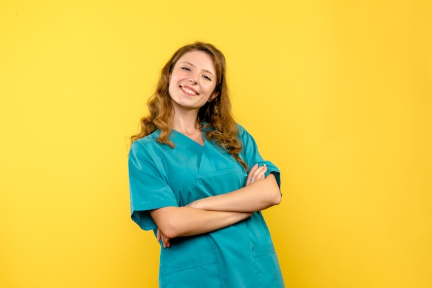 Foto grátis vista frontal da médica sorrindo na parede amarela