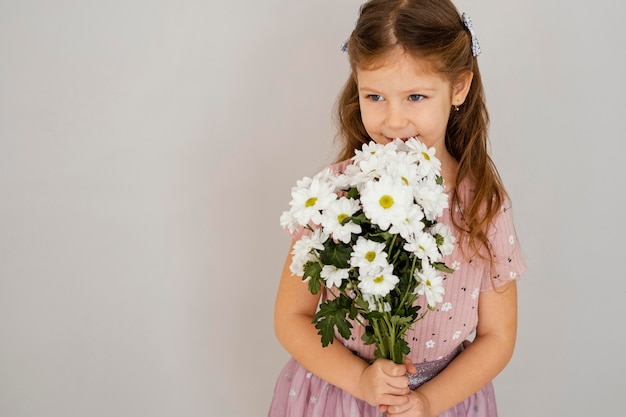 Vista frontal da menina segurando um buquê de flores da primavera com espaço de cópia
