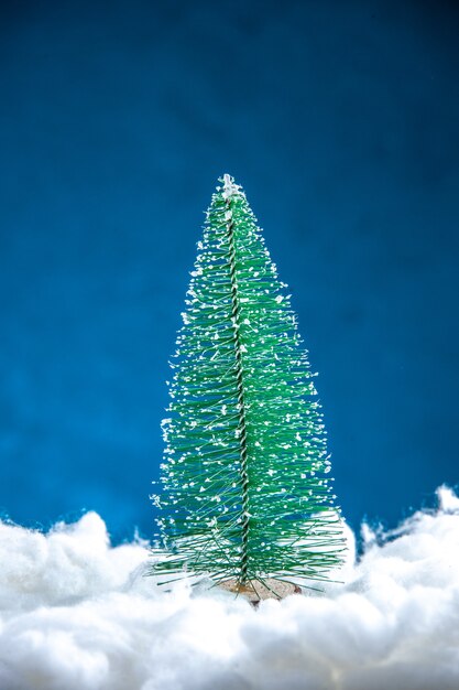 Vista frontal da mini árvore de natal em fundo branco azul