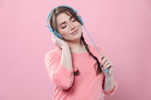 Vista frontal da mulher a gostar de música em fones de ouvido