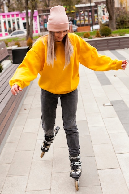 Vista frontal da mulher com patins de gorro