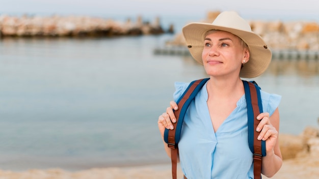 Vista frontal da mulher mais velha do turista com chapéu de praia