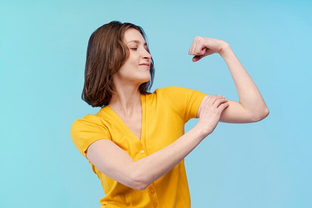 Vista frontal da mulher mostrando seu bíceps forte
