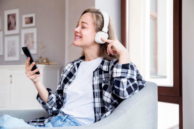 Vista frontal da mulher ouvindo música