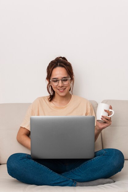 Vista frontal da mulher que trabalha no seu laptop