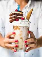 Foto grátis vista frontal da mulher segurando delicioso milkshake