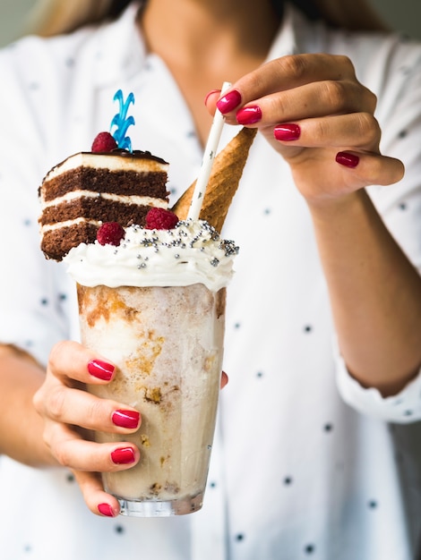 Foto grátis vista frontal da mulher segurando delicioso milkshake