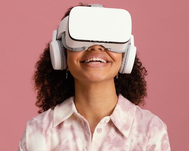 Vista frontal da mulher sorridente com fone de ouvido de realidade virtual