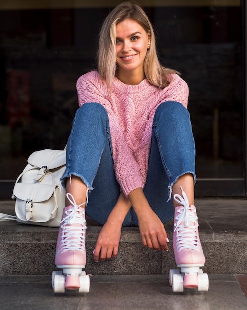 Vista frontal da mulher sorridente em patins