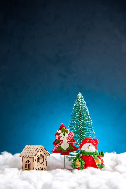 Vista frontal da pequena casa de madeira de brinquedos de natal em fundo azul