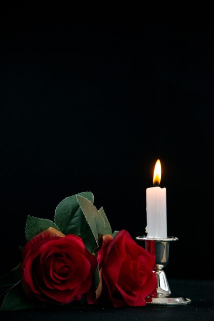 Vista frontal da pequena sepultura com uma vela acesa no preto