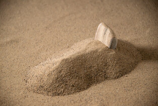 Vista frontal da pequena sepultura de pedra na areia da lua