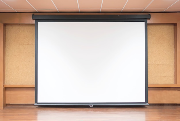 Vista frontal da sala de aula com tela de projeção branca vazia