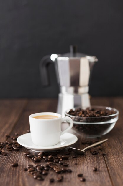 Vista frontal da xícara de café com panela e colher