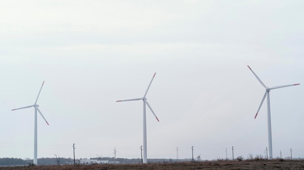 Vista frontal das turbinas eólicas no campo gerando energia elétrica