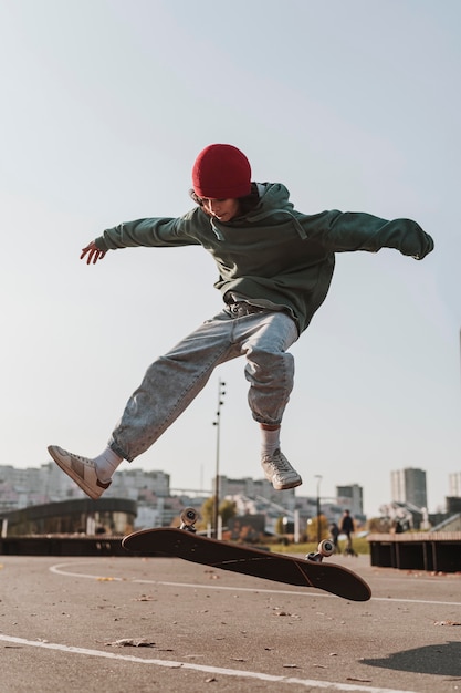 Vista frontal de adolescente com skate do lado de fora