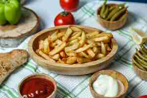 Foto grátis vista frontal de batatas fritas com ketchup e maionese de tomate e pimentão na mesa