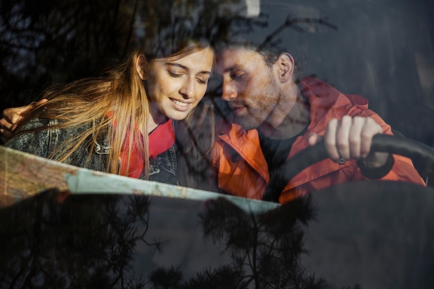 Foto grátis vista frontal de casal com mapa dentro do carro, fazendo uma viagem juntos