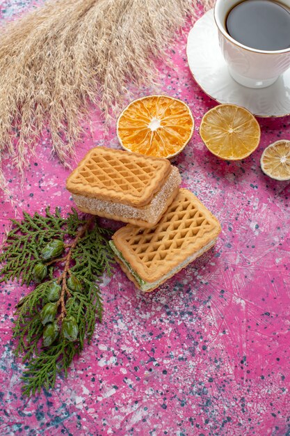 Vista frontal de deliciosos biscoitos waffle com uma xícara de chá