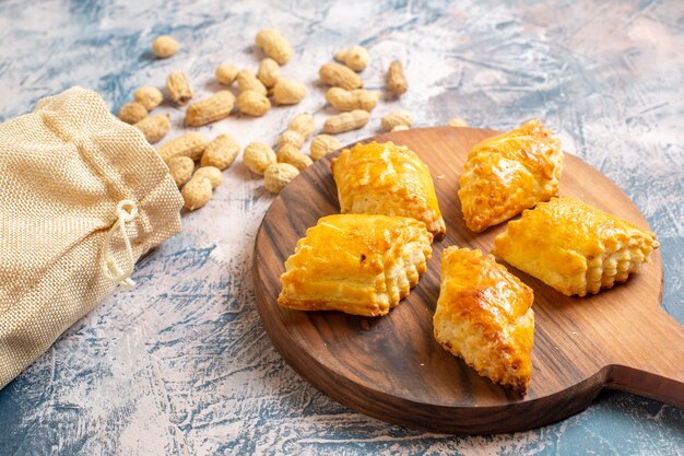 Vista frontal de deliciosos pastéis doces com amendoim na superfície azul