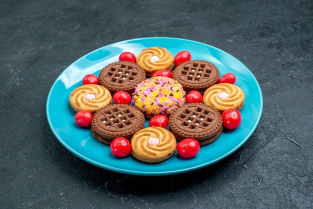 Vista frontal de diferentes biscoitos de açúcar dentro do prato com doces em uma superfície cinza doce açúcar doce chá biscoitos biscoito