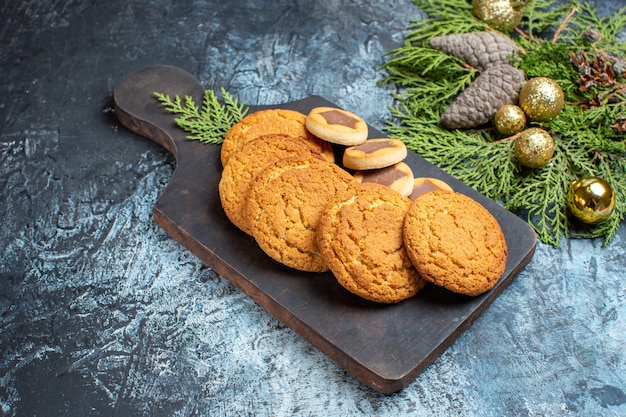 Vista frontal de diferentes biscoitos deliciosos em superfície claro-escuro