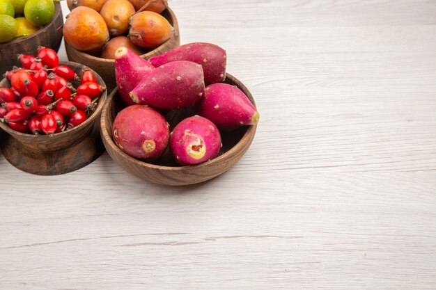 Foto grátis vista frontal de diferentes frutas frescas dentro de pratos em fundo branco cor tropical vida saudável baga árvore madura exótica