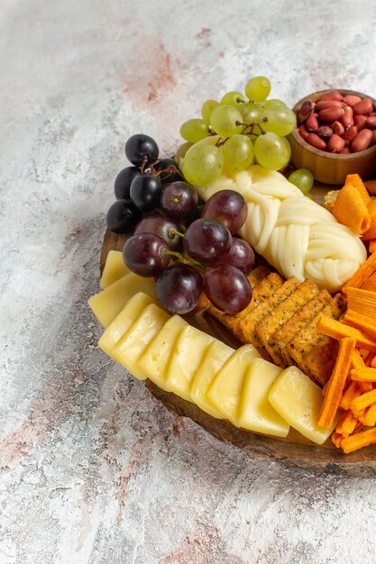 Vista frontal de diferentes lanches nozes cips uvas queijo e salsichas no fundo branco porca lanche refeição alimentos frutas