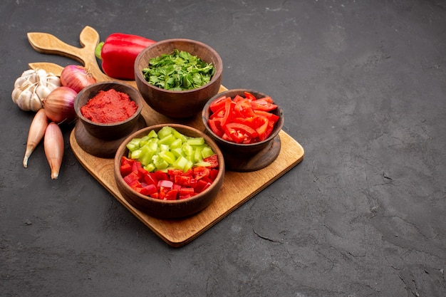 Vista frontal de diferentes vegetais com verduras em fundo cinza salada refeição saúde madura picante