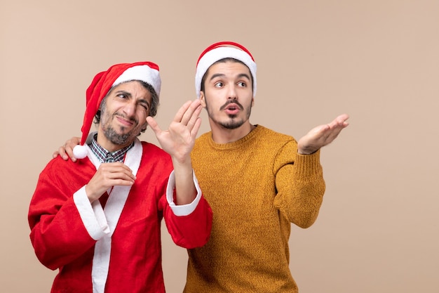 Vista frontal de dois homens olhando para algum lugar em um fundo bege isolado