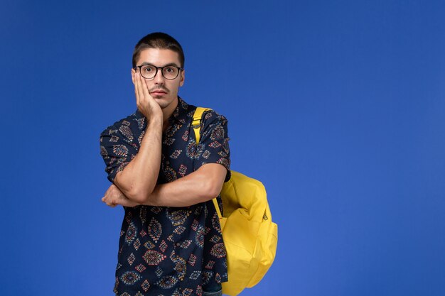 Vista frontal de estudante do sexo masculino com camisa escura e mochila amarela