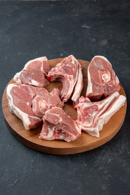 Vista frontal de fatias de carne fresca carne crua em um fundo escuro refeição comida frescura animal vaca comida cozinha