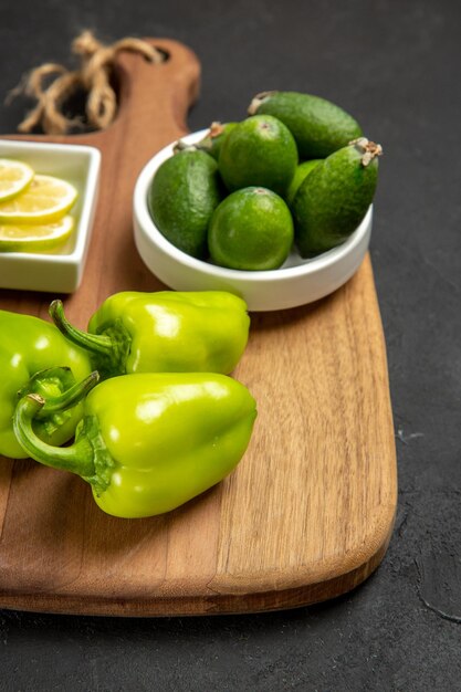 Vista frontal de feijoa fresca com pimentão verde e limão na superfície escura fruta saudável planta farinha de cítricos