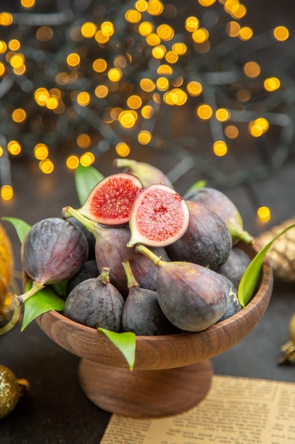 Foto grátis vista frontal de figos frescos ao redor de brinquedos de natal em um fundo escuro fruta escura sabor foto de natal