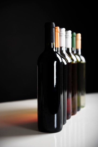 Vista frontal de garrafas de vinho em uma fileira