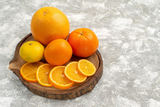 Vista frontal de laranjas frescas com tangerinas em fundo branco claro frutas cítricas tropicais exóticas