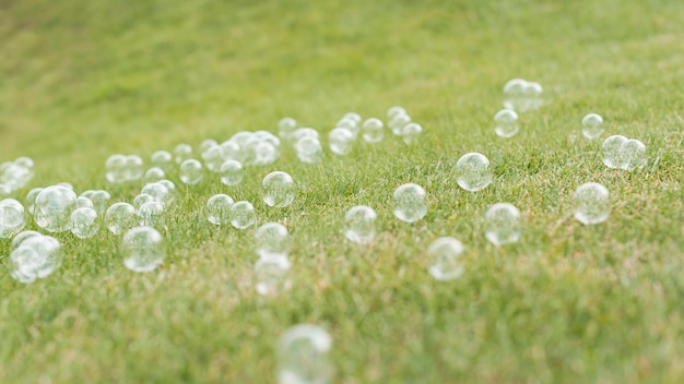 Vista frontal de lindas bolhas de sabão na grama