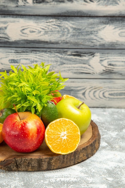 Vista frontal de maçãs frescas com laranjas fatiadas no fundo cinza maçã fresca de frutas maduras maduras