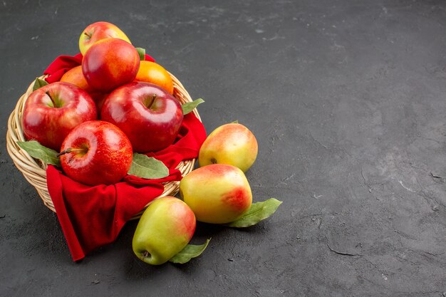 Vista frontal de maçãs frescas dentro de uma cesta na mesa escura de frutas maduras frescas