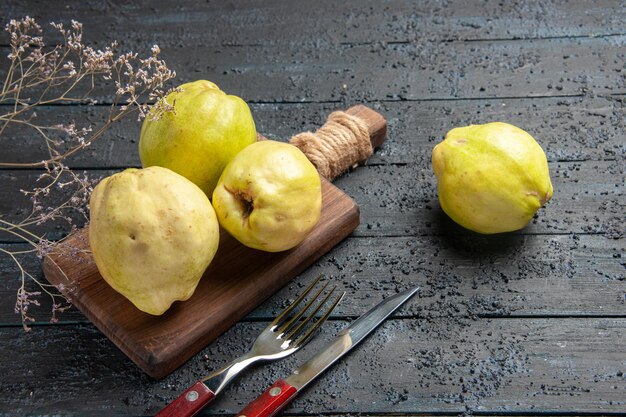 Vista frontal de marmelos frescos frutas azedas e maduras em mesa rústica azul-escura plantar árvore frutífera madura fresca