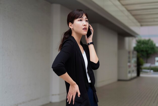 Vista frontal de mulher falando ao telefone