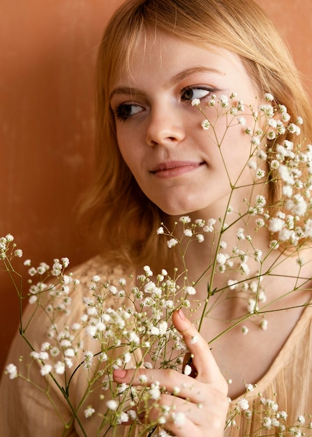 Vista frontal de mulher posando com lindas flores