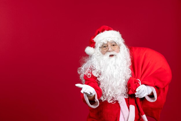 Vista frontal de Papai Noel carregando saco vermelho cheio de presentes em emoção vermelha feriados de Natal de ano novo