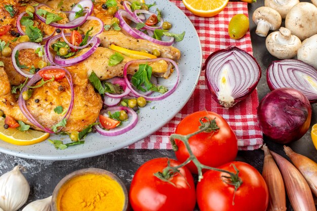 Vista frontal de perto de um delicioso jantar prato de frango frito com várias especiarias e alimentos alhos garrafa de óleo caído limão cebolas cogumelos kumquats