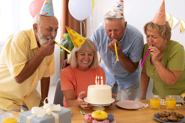 Vista frontal de pessoas idosas comemorando aniversário